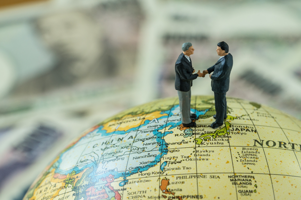Men shaking hands on map of Japan